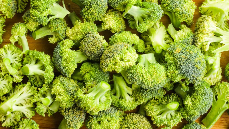 Looking down on a cutting board filled with broccoli florets.