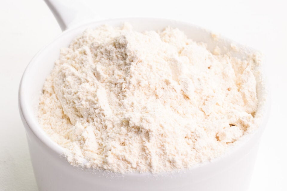 A pile of flour has been poured into a measuring cup.