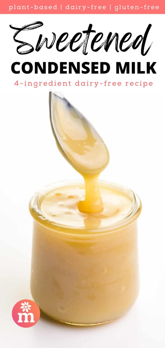 Creamy, dairy-free sweetened condensed milk dripping from a spoon, set against a plain background.
