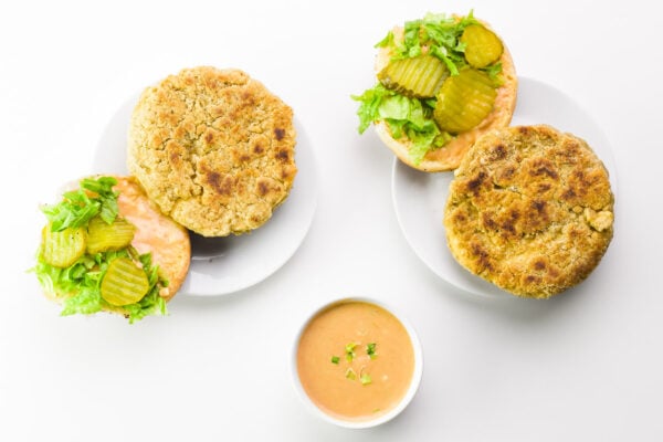 Looking down on open-faced tofu sandwiches with a bowl of special sauce sitting between them.