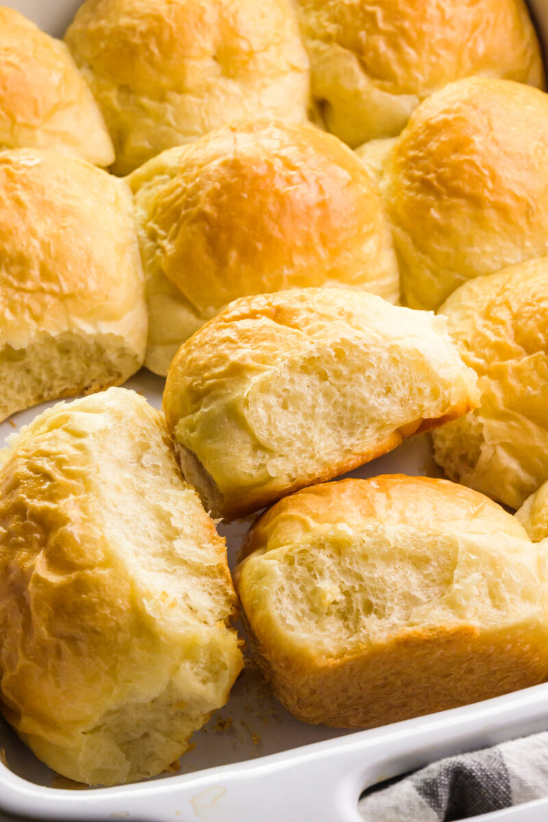 Looking down on dinner rolls in a baking dish, with some of them turned sideways.