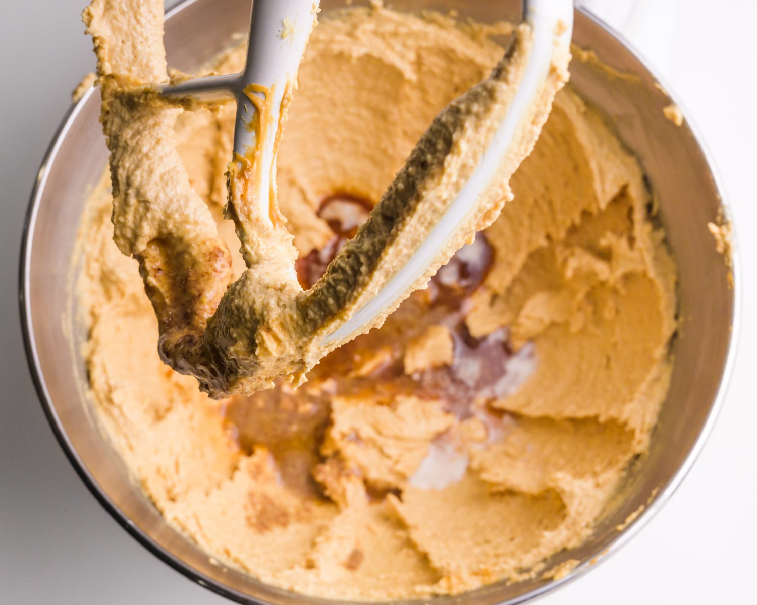 Looking down on peanut butter cookie dough batter in a stand mixer.