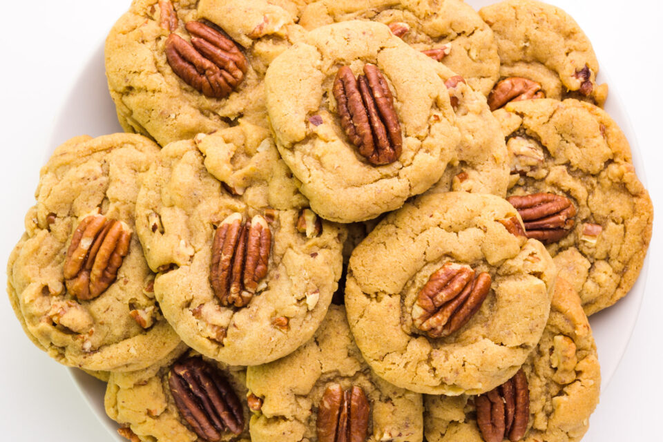 Looking down on vegan pecan cookies on a plate.