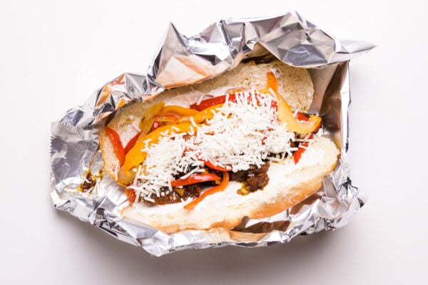 A vegan cheesesteak sandwich sits in foil waiting to be baked.