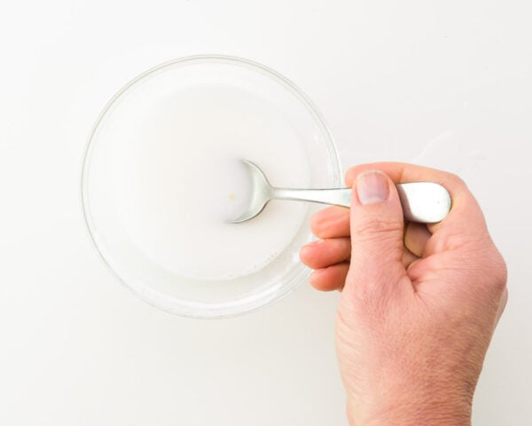 A hand stirs together an egg replacer mixture.