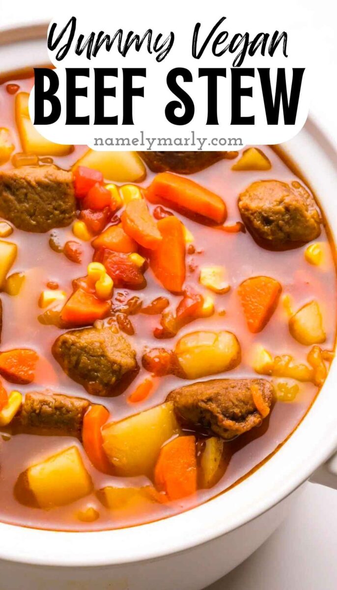 Vegan beef stew with carrots, potatoes, corn, and textured vegetable protein in a white bowl.