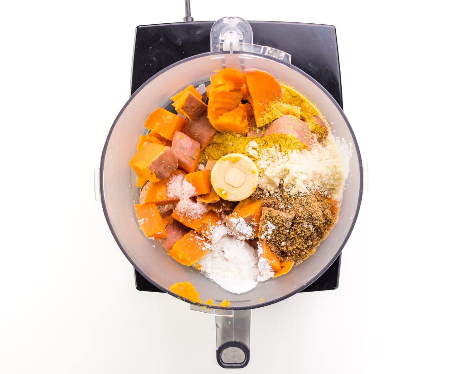 Mashed sweet potatoes and other ingredients are in a food processor.