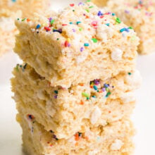 A stack of vegan Rice Krispie treats sits in front of other treats in the background.