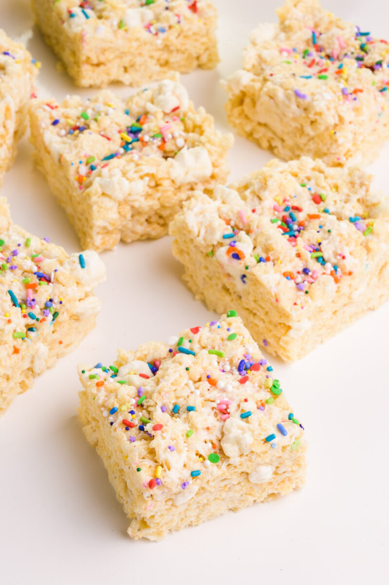 Looking down on rice crispy squares on a white table.