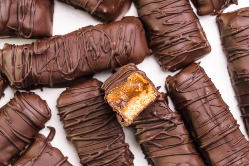 Looking down on several vegan chocolate candy bars, one with a bite taken out.