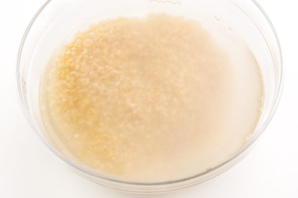 Cloudy water is obvious in this bowl of brown rice soaking in water.