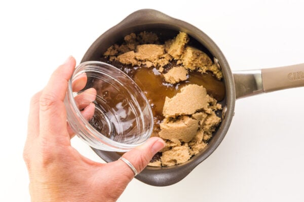 Water is being poured over a saucepan with brown sugar.