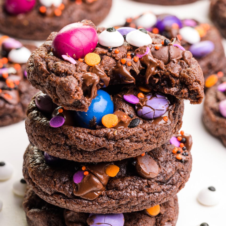 A stack of Halloween vegan cookies shows the top one with a bite taken out.