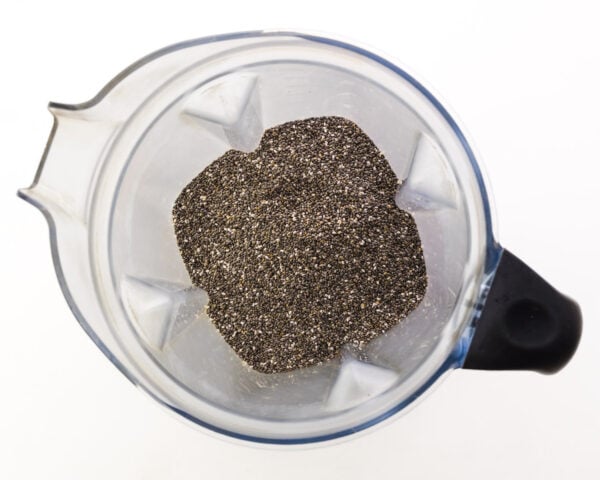 Chia seeds are in the bottom of a blender jar.