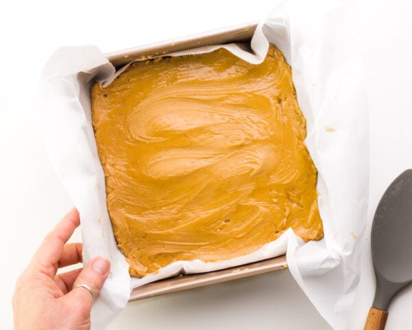 A hand holds a pan full of vegan peanut butter fudge.