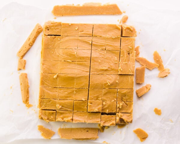 Peanut butter fudge has been removed from a pan and cut into squares.