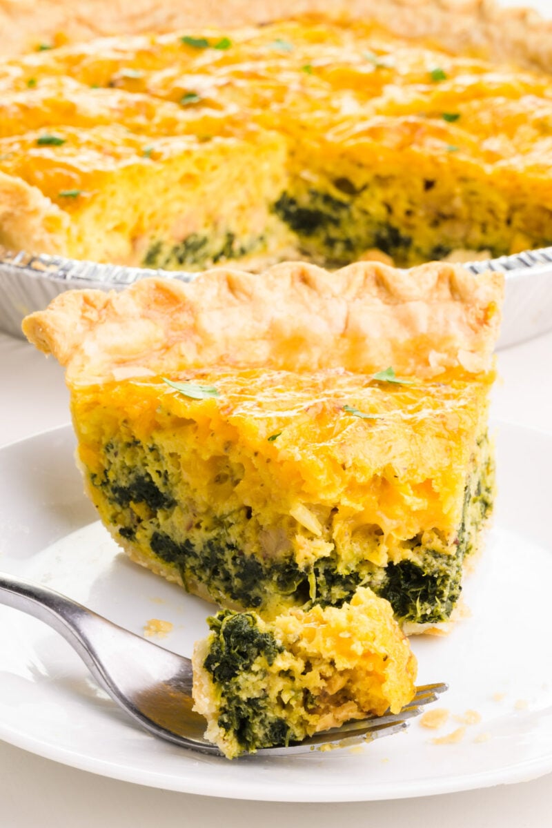 A bite of Just Egg quiche sits on a fork in front of the slice. The rest of the quiche is in the background.