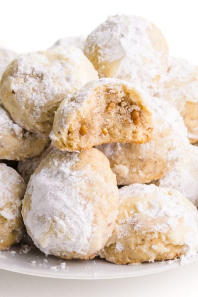 A plateful of vegan snowball cookies sit on a white counter.
