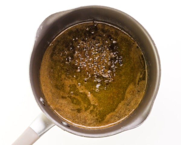 A hot sugar mixture is coming to a boil in a saucepan.
