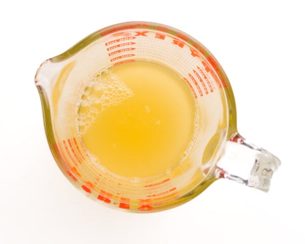 Looking down on a measuring cup with bean brine from a can of chickpeas.
