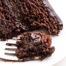 Looking down on a slice of cake on a plate. A bite has been taken and it sits on a fork.