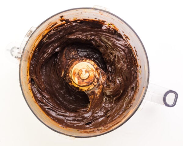 Looking down into a food processor with thick, chocolate mixture in it.