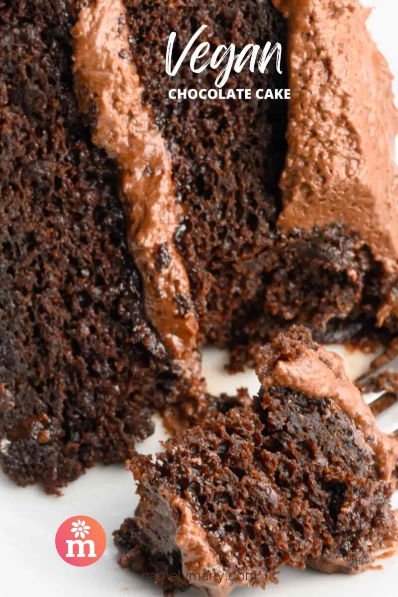 A closeup of a layered chocolate cake with a bite taken out. The text reads, Vegan Chocolate Cake.
