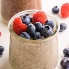 A closeup of chia pudding in a jar with fresh fruit on top.