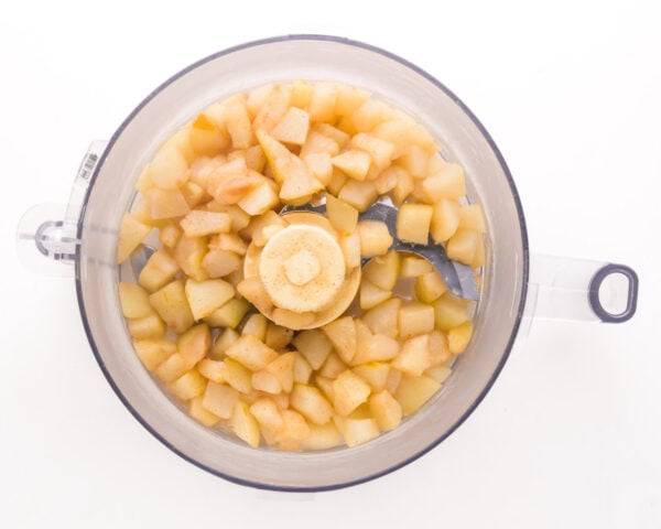 Cooked chopped pears are in a food processor bowl, waiting to be pureed.