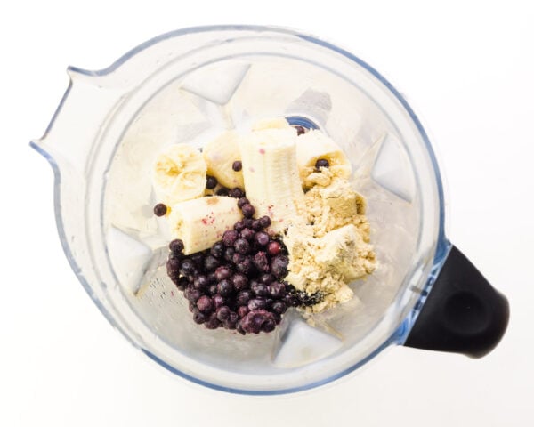 Looking down on frozen fruit in a blender jar.