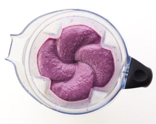 Looking down on purple smoothie mixture in a blender jar.