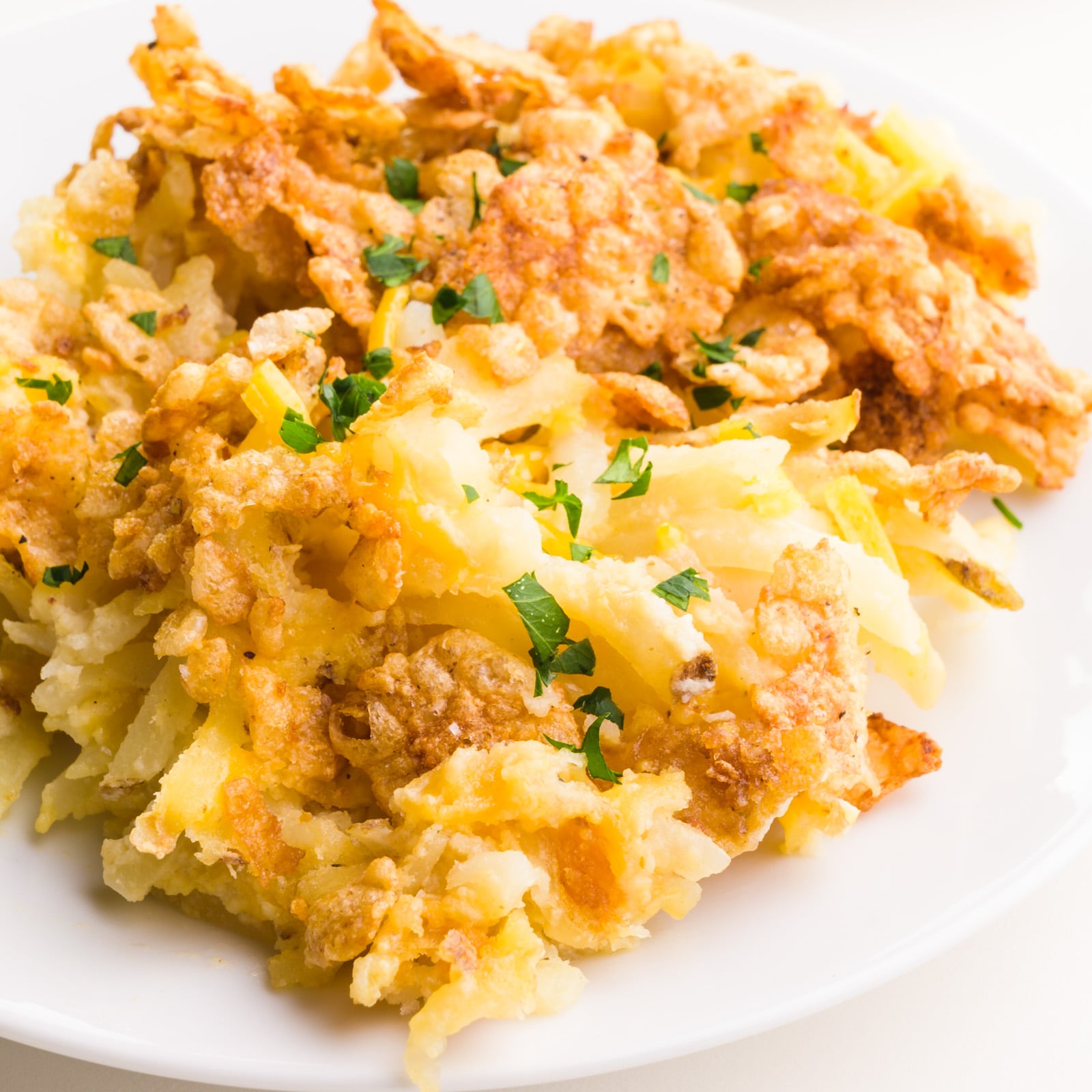 A closeup of vegan funeral potatoes on a plate.