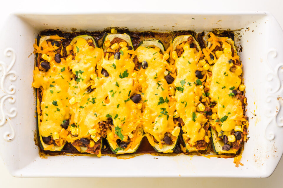 Looking down on zucchini boats in a baking dish.