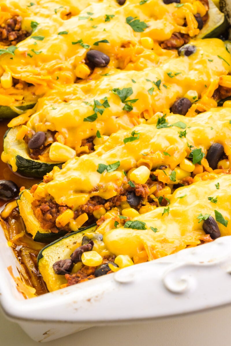 Looking down on cheesy zucchini boats in a baking dish.
