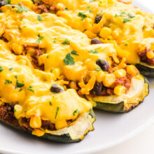 A close-up of vegan zucchini boats on a plate.