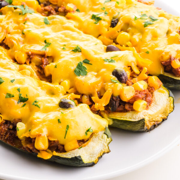 A close-up of vegan zucchini boats on a plate.