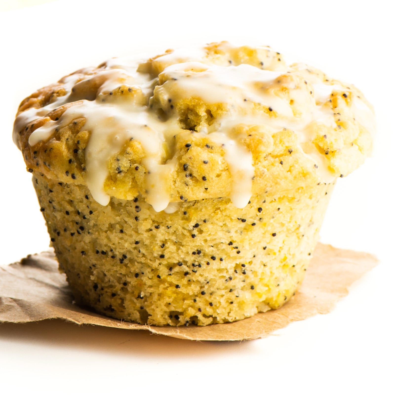 An orange muffin sits on a piece of parchment paper.