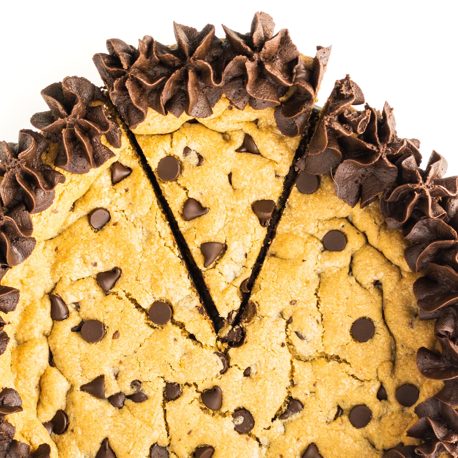 Cookie cake topped with chocolate frosting and chocolate chips, cut into slices.
