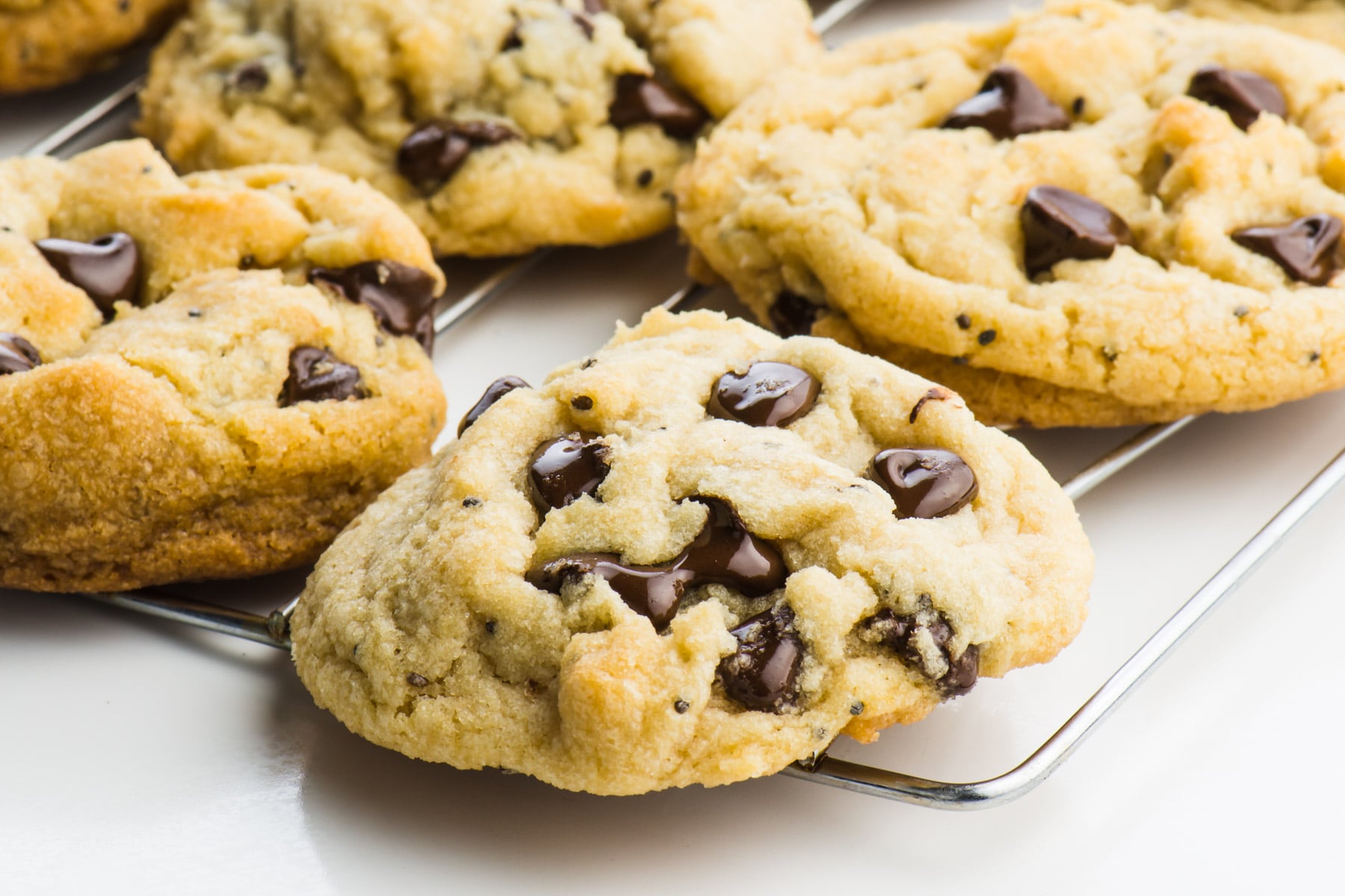Several chocolate chip cookies on a wire rack.