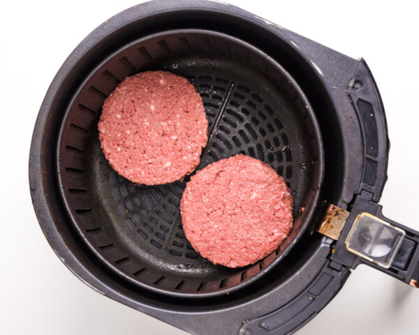 Looking down on Impossible Burgers in an air fryer basket.