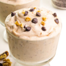A closeup of chunky monkey nice cream with chocolate chips and walnuts on top.
