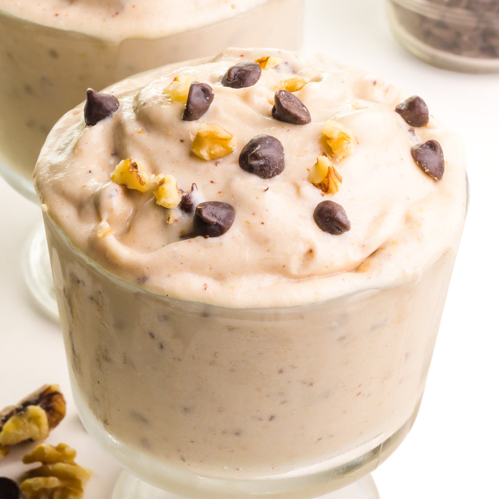 A closeup of chunky monkey nice cream with chocolate chips and walnuts on top.