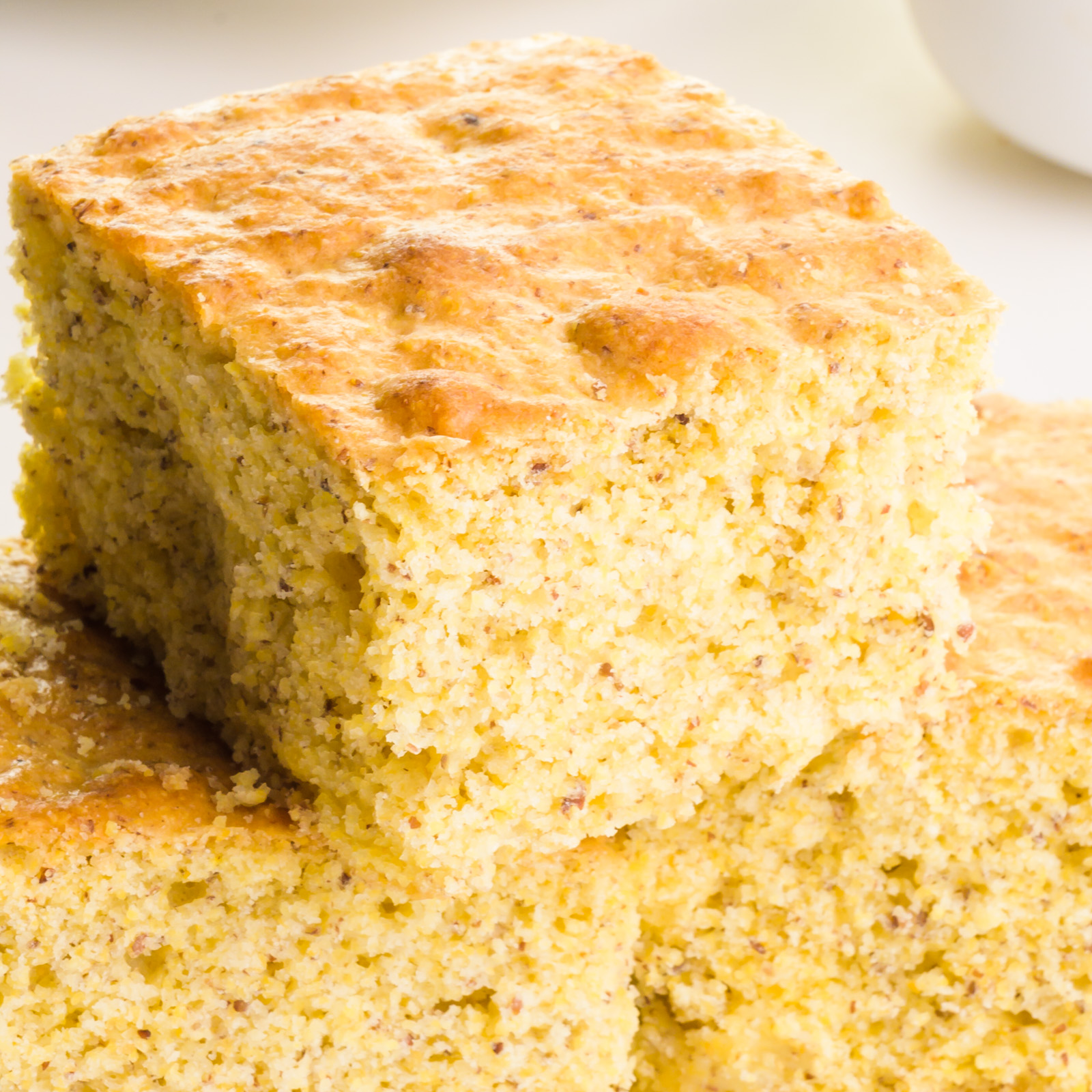 A slice of cornbread sits on top of two other slices.
