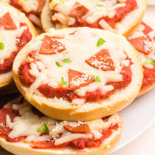 A closeup of vegan pizza bagel bites on a plate.