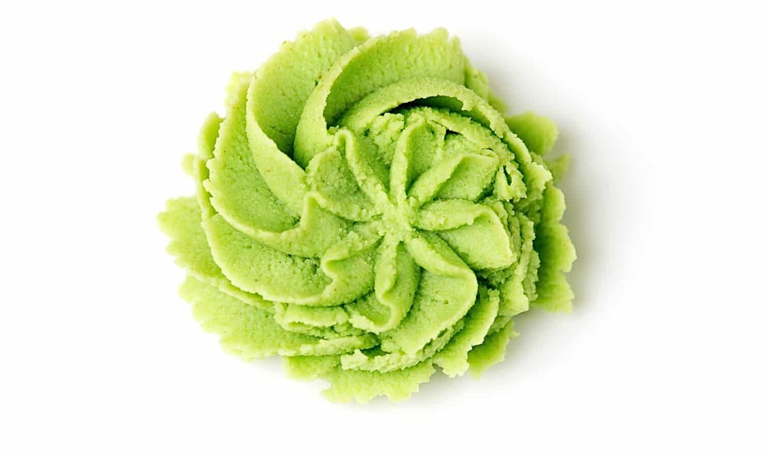 Looking down on wasabi paste that has been pressed from a frosting bag using a star tip, leaving behind a decorative flower-like shape.