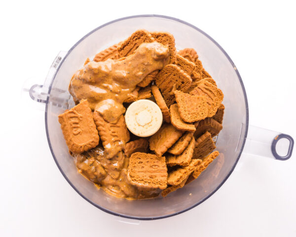 Biscoff cookies are in a food processor along with some almond butter.
