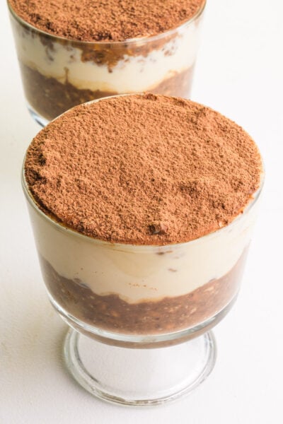 Two dishes of tiramisu overnight oats sit on a white counter.