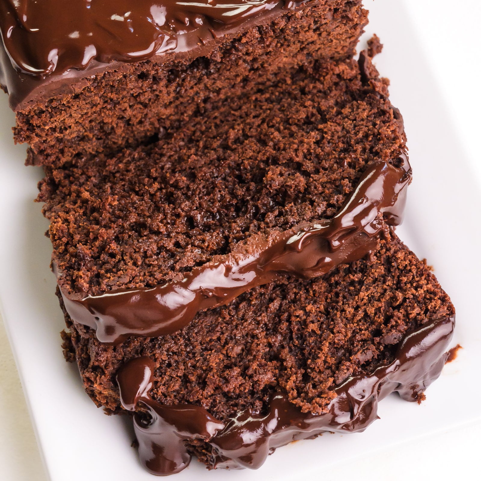 Looking down on a loaf of chocolate bread with a few slices in front of it.