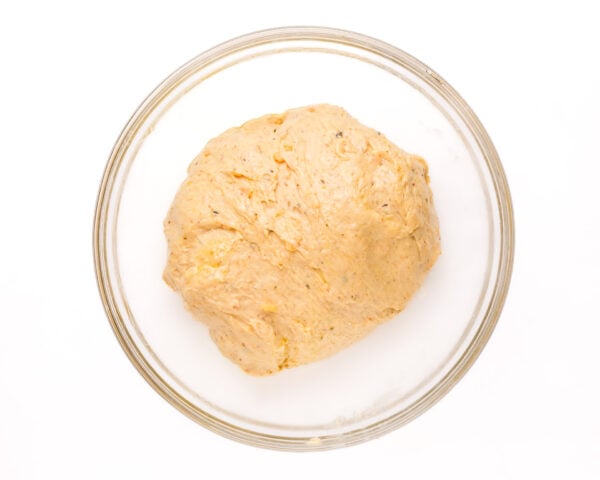 Sweet potato dough is in a greased bowl, ready for its first rise.