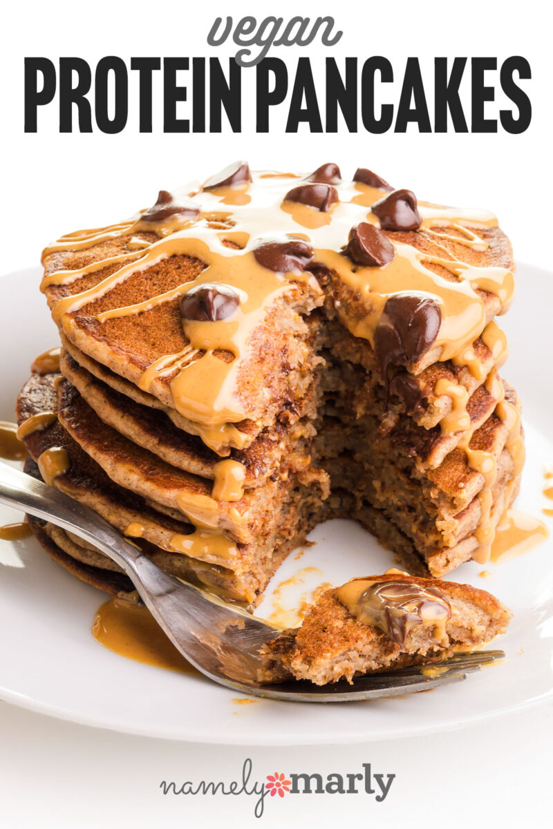 Stack of vegan protein pancakes drizzled with peanut butter and topped with chocolate chips, with a fork on the side.